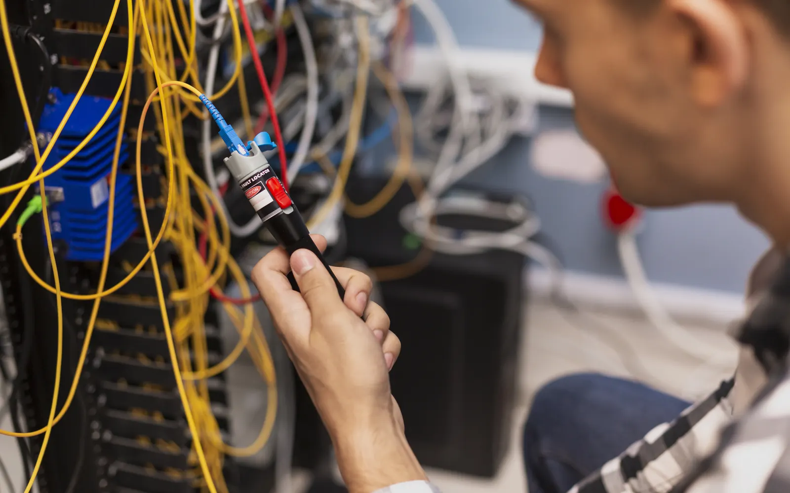 Techniker verbindet Glasfasern an einem optischen Verteilergestell im Technikraum